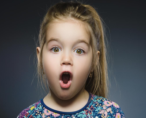 A young girl making a surprised face because she just found out what lice was!