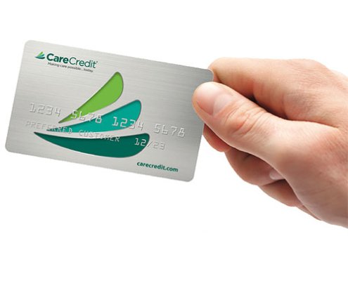 A hand holding a CareCredit card