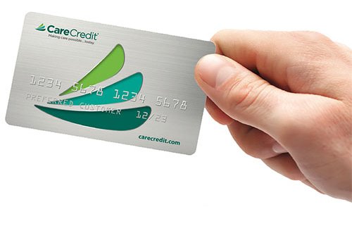 A hand holding a CareCredit card